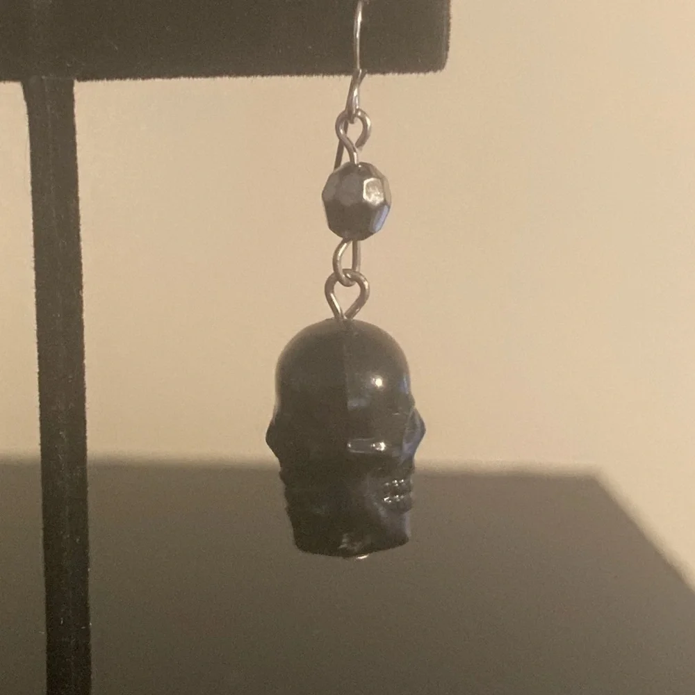 Single (not a pair) black skull earring.